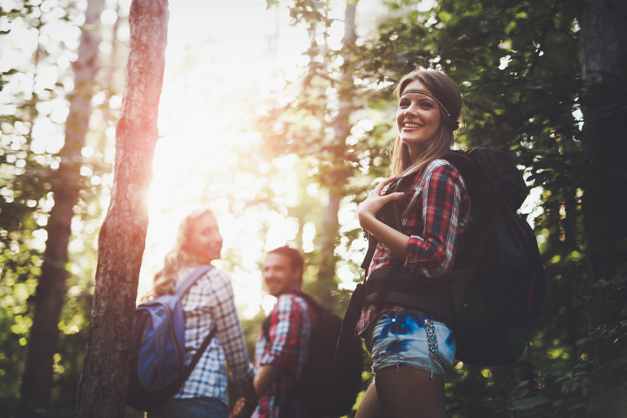 Beautiful woman and friends hiking and backpacking in forest Beautiful woman and friends hiking and backpacking in forest