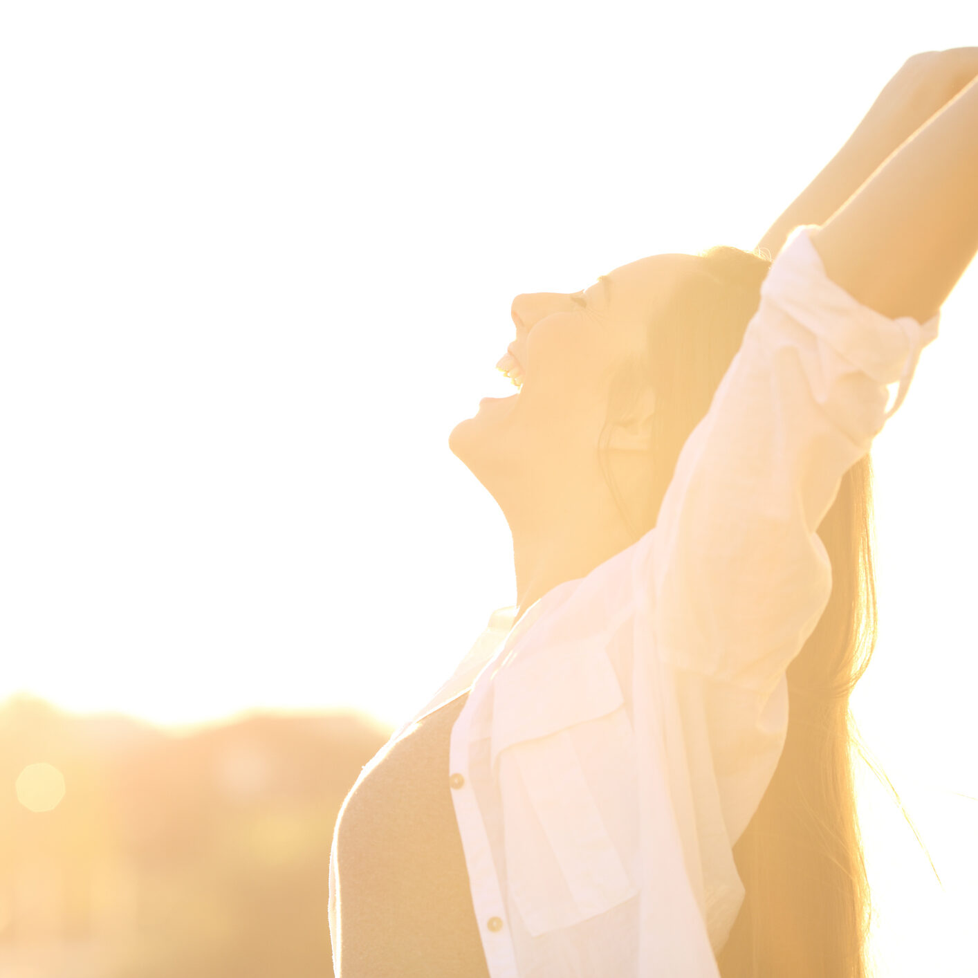 Side view portrait of an excited woman raising arms at sunset
